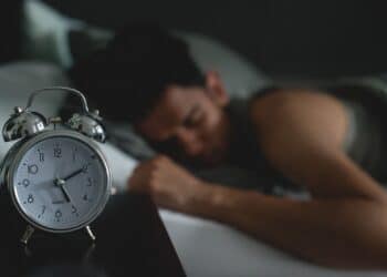 Sleeping in bed with alarm clock