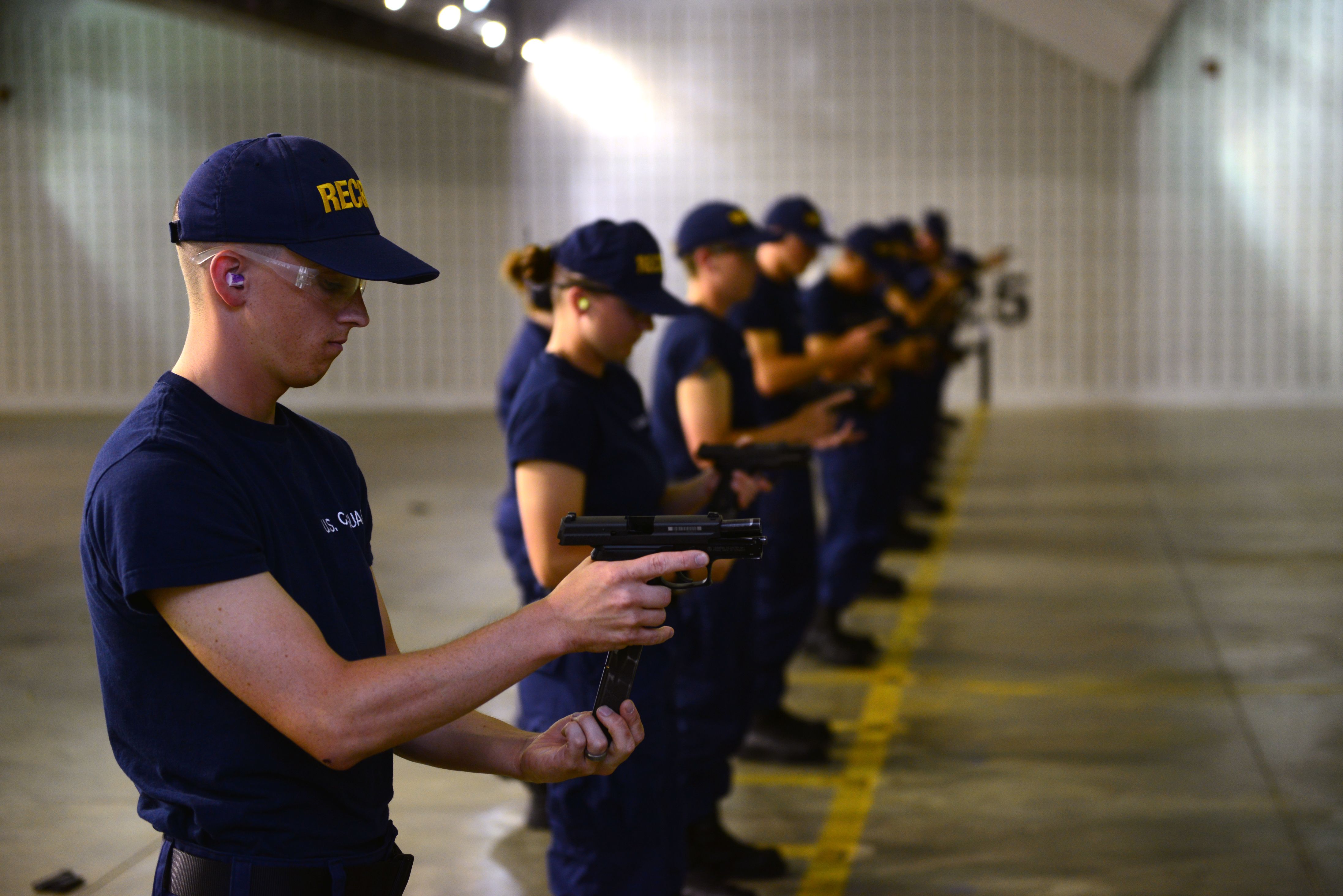 Seaman Recruit Martin Bunn slips a magazine into the Coast Guard's standard issue Sig Sauer P229 .40-caliber during a live-fire exercise at the FAA Technical Center in Galloway, N.J., July 1, 2015. Bunn and the rest of recruit company Lima 191 were transported via bus from the Coast Guard Training Center to the FAA facility to utilize their indoor range. (U.S. Coast Guard photo by Chief Warrant Officer John Edwards)