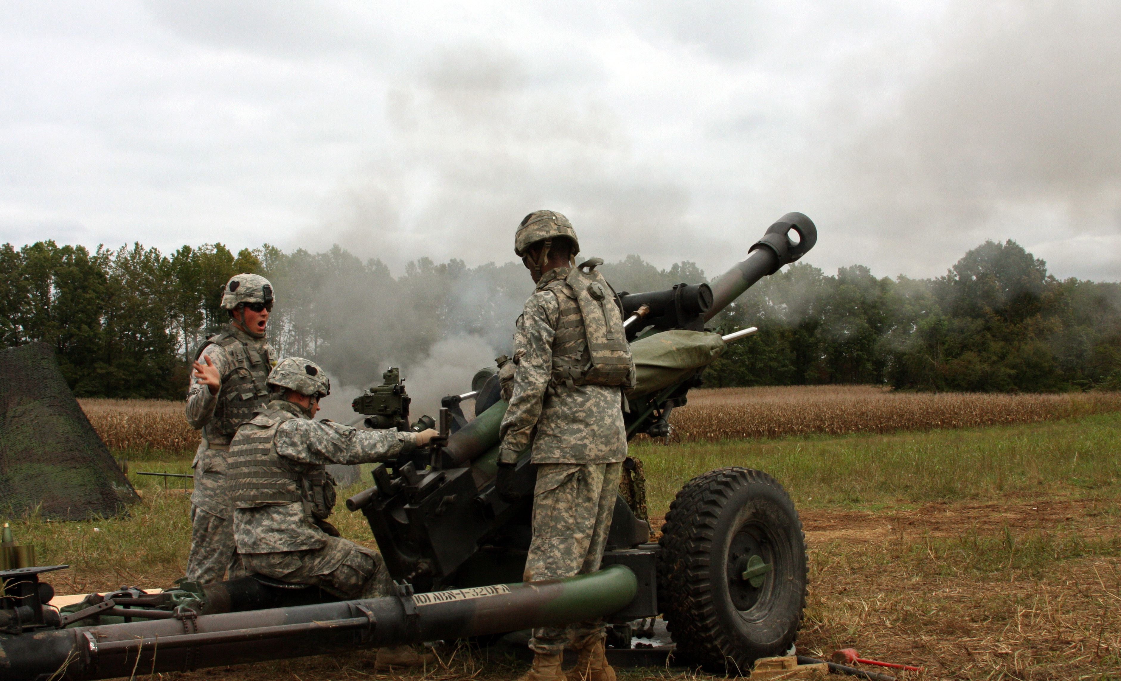 (Far Left) Sgt. James Bartoszek with Battery B, 1st Battalion, 320th Field Artillery Regiment, 2nd Brigade Combat Team, 101st Airborne Division (Air Assault), yells the command ?fire? during the brigade?s combined arms Walk and Shoot exercise Oct. 5. Artillerymen remain a vital component in accurately and quickly defeating, neutralizing and suppressing the enemy.