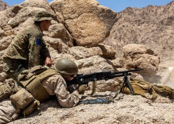 A U.S. Marine with 2nd Battalion, 1st Marines, attached to the Special Purpose Marine Air – Ground Task Force – Crisis Response - Central Command (SPMAGTF-CR-CC) 21.1, fires a L7A2 General Purpose Machine Gun while being observed by a British Army Soldier with 2nd Battalion, Parachute Regiment