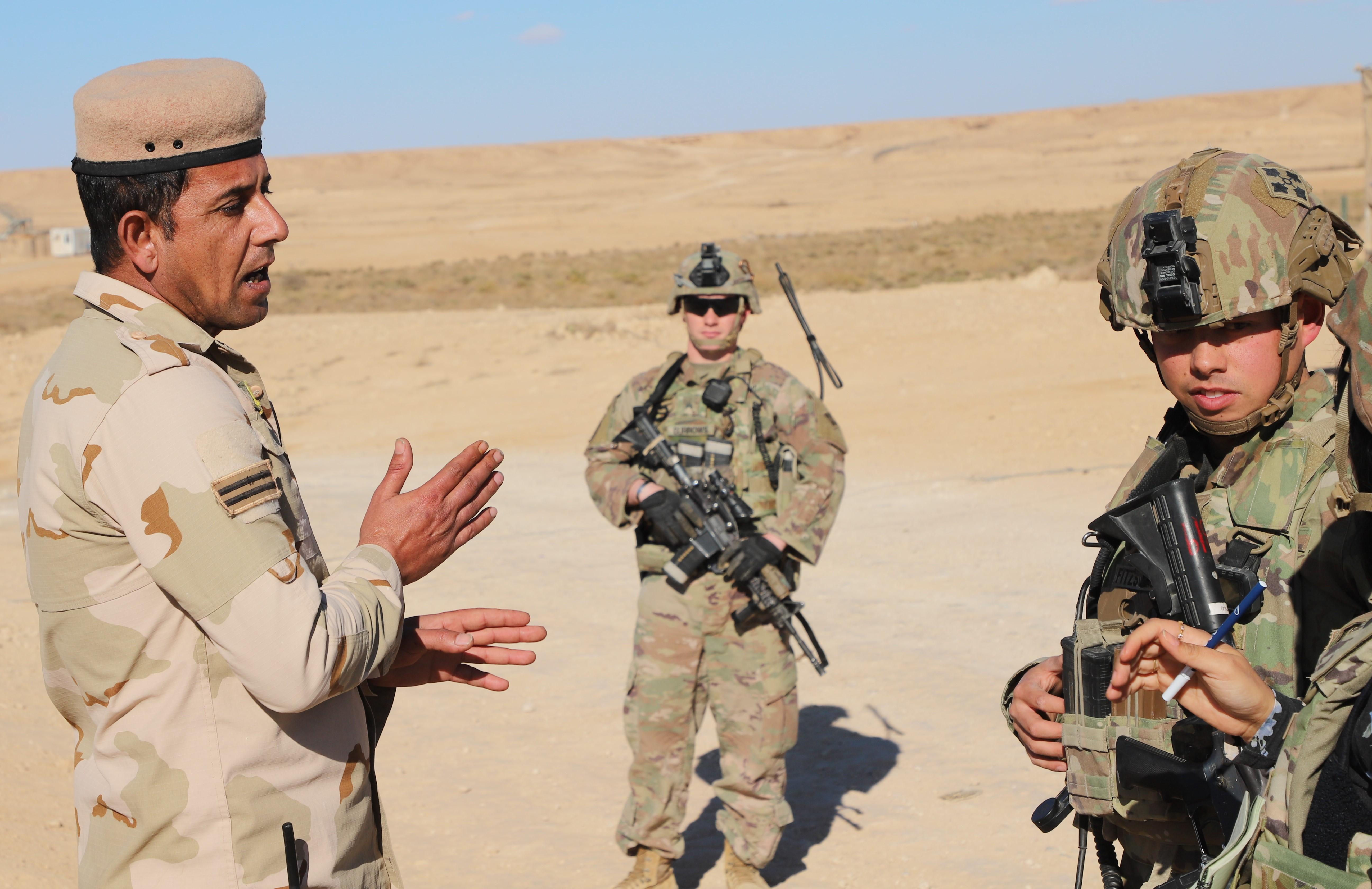 1st Lt. Matthew Fitzsimmons, platoon leader, Bravo Company, 4th Battalion, 9th Infantry Regiment, 1st Stryker Brigade Combat Team, 4th Infantry Division speaks with Spc. Ahmad Ali Khalaf, an Iraqi soldier stationed at a perimeter outpost at Al Asad Air Base on Dec. 21 2021