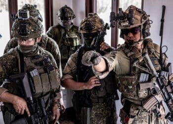 MANILA, Philippines- A Green Beret with the 1st Special Forces Group (Airborne) and Philippine Marines discuss security placement after securing a building during a simulated raid April 7, 2022. The U.S. and Philippines share a long history of collaboration toward shared values, and our alliance is further strengthened by cultural exchanges and strong people-to-people ties. (U.S. Army Photo by Sgt. 1st Class Ryan Hohman) (This photo was altered for security purposes)