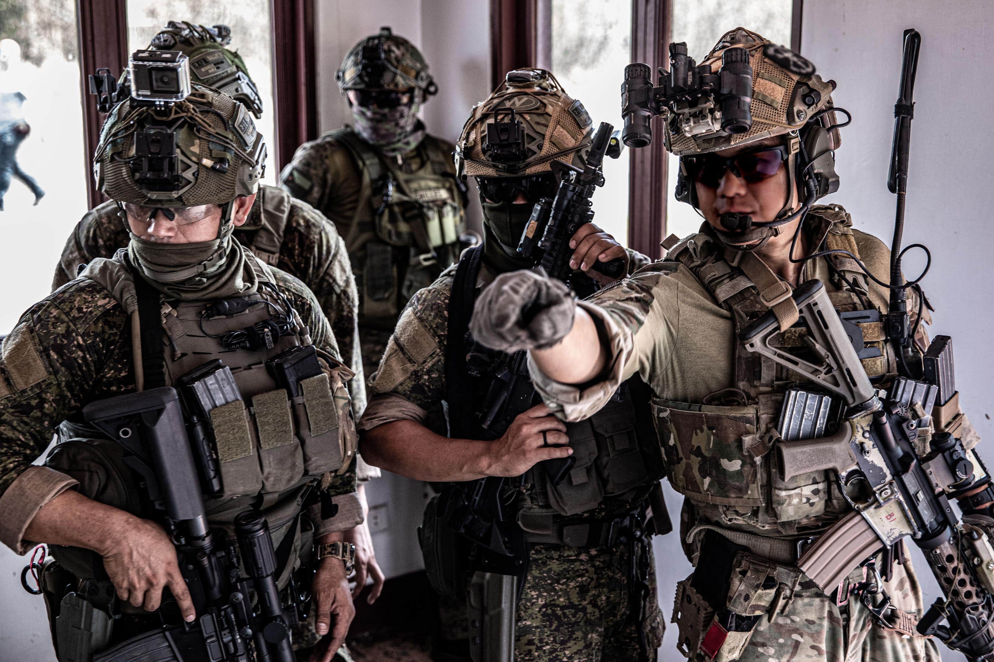 MANILA, Philippines- A Green Beret with the 1st Special Forces Group (Airborne) and Philippine Marines discuss security placement after securing a building during a simulated raid April 7, 2022. The U.S. and Philippines share a long history of collaboration toward shared values, and our alliance is further strengthened by cultural exchanges and strong people-to-people ties. (U.S. Army Photo by Sgt. 1st Class Ryan Hohman) (This photo was altered for security purposes)