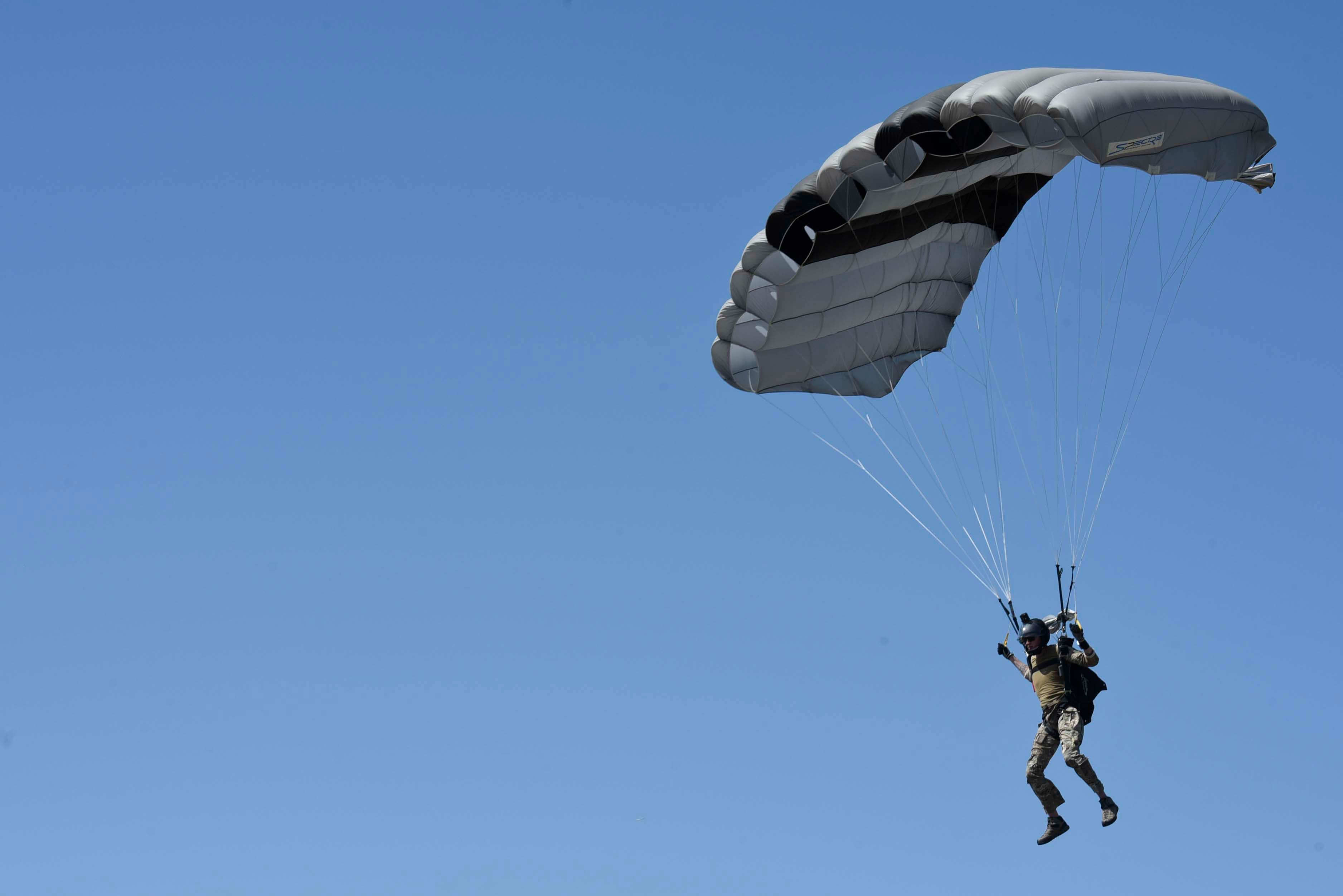 A Survival, Evasion, Resistance and Escape (SERE) Specialist, from the 22nd Training Squadron, safely parachutes to the flightline during training at Fairchild Air Force Base, Washington May 31, 2023. Parachuting is an integral part of SERE training that ensures the readiness of the Airmen who go through the course. (U.S. Air Force photo by Airman 1st Class Clare Werner)