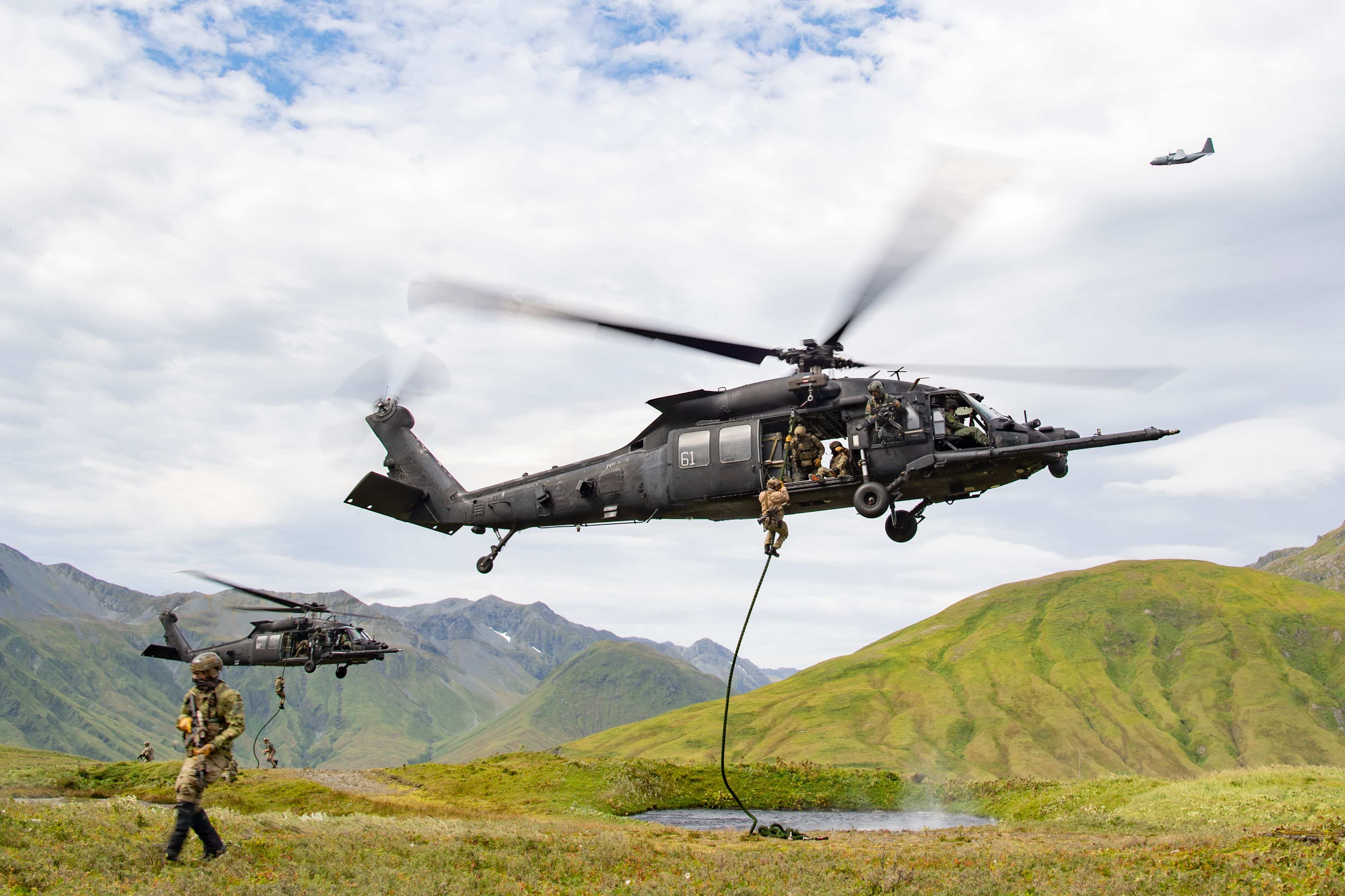 East-Coast-based U.S. Naval Special Warfare Operators (SEALs) fast-rope from U.S. Army MH-60M helicopters, assigned to the 160th Special Operations Aviation Regiment (SOAR), while an AC-130J Ghostrider provides overwatch on Attu Island, Alaska, Aug. 31, 2023