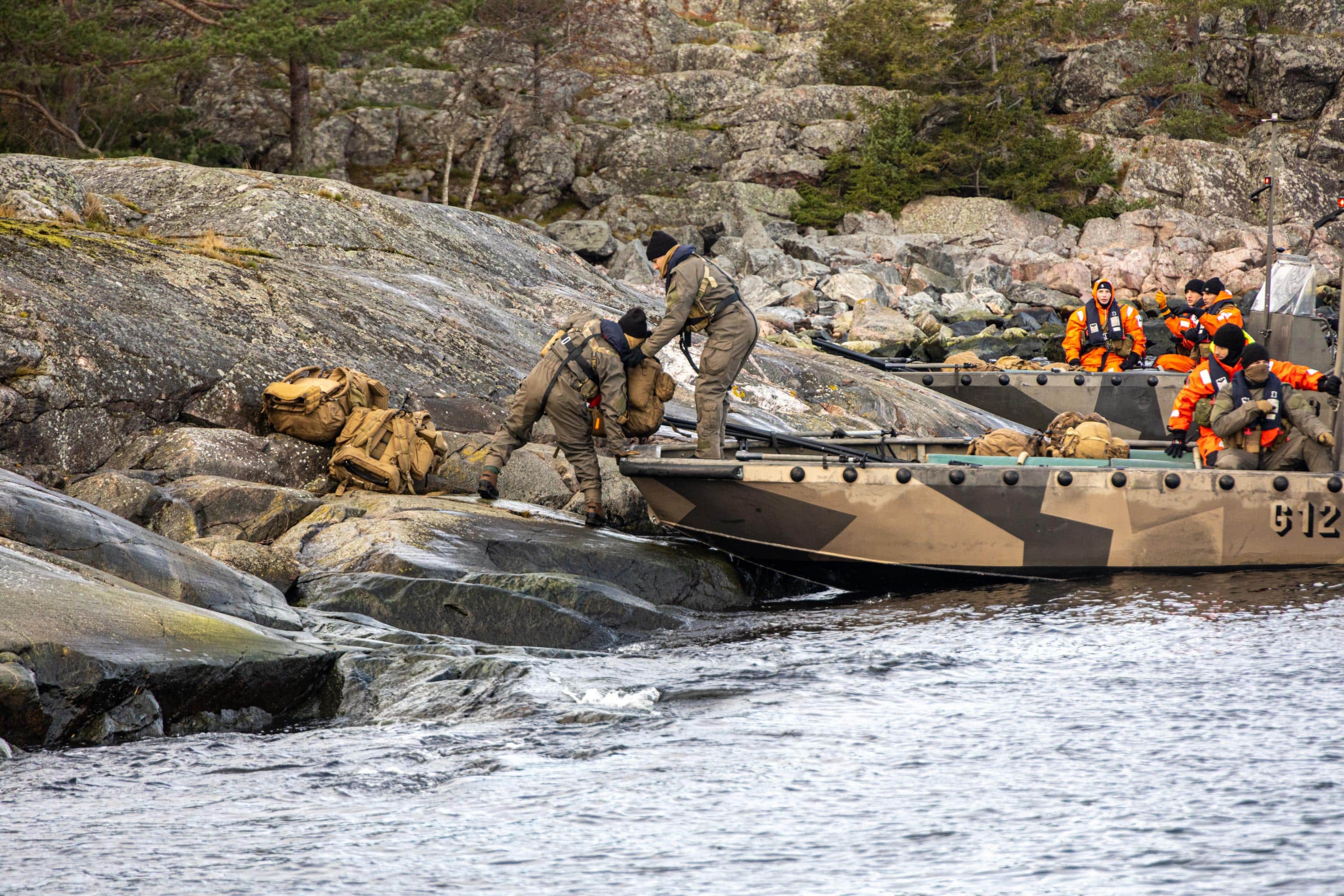 U.S. Marines from 2nd Reconnaissance Battalion, 2nd Marine Division, unload gear from a Finnish G -Class landing craft during trial insertion and extraction drills in part of Freezing Winds 23 (FW23) off the coast of Finland, Nov. 2, 2023.