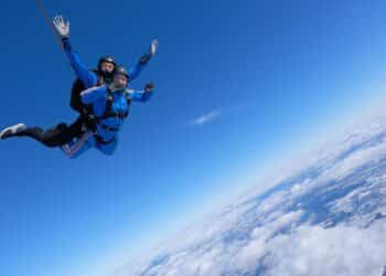 Two guys are jumping a skydiving tandem.