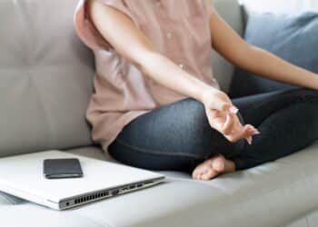 body of woman exercise by pose yoga meditation with turn off computer and mobile phone, self care calm activity at home, social stop or disconnect digital detox concept.