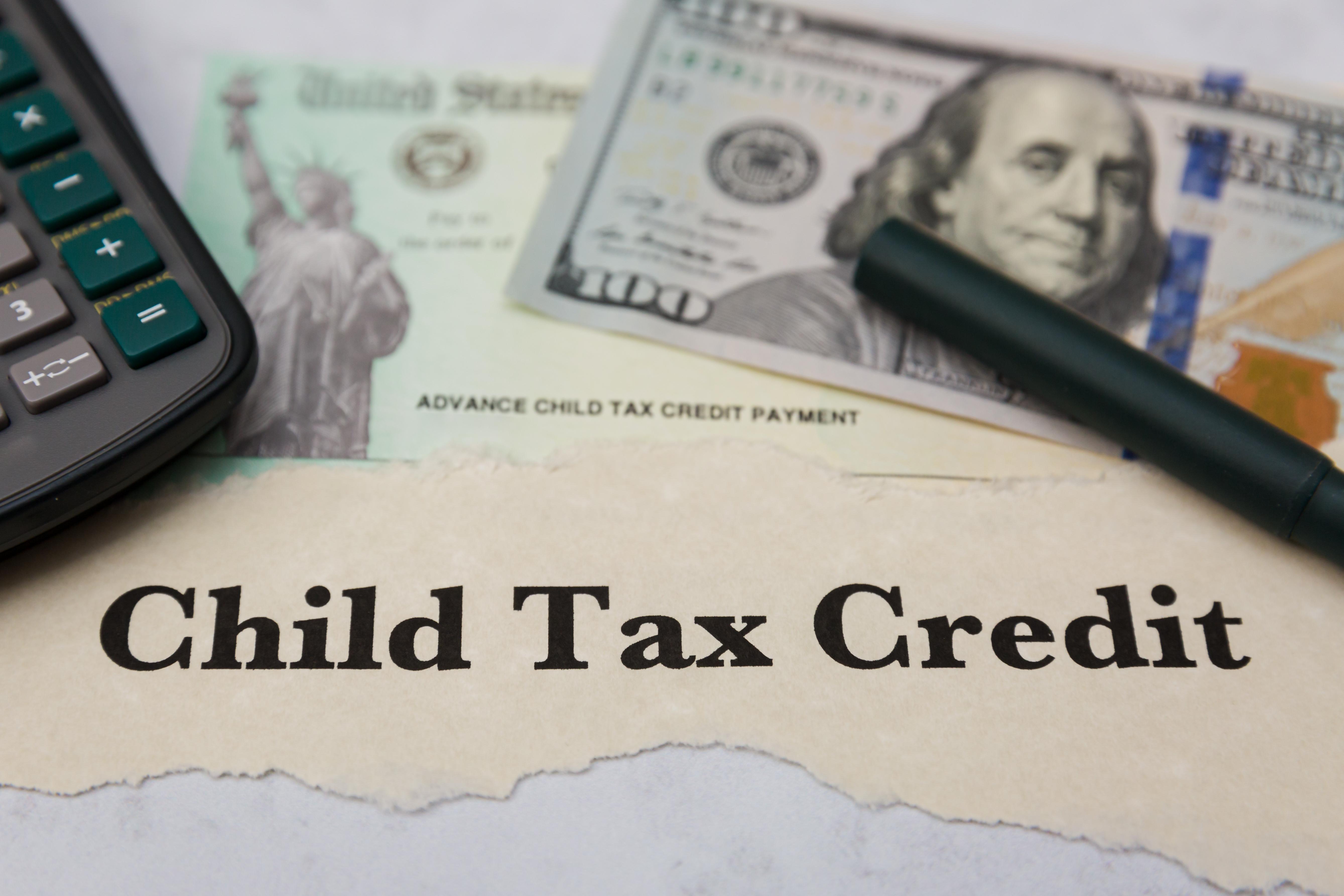 Child Tax Credit - Calculator, Dollar Bill, IRS Check, and Pen