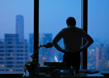 Rear view - Asian business man being frustrated standing in office hopelessly