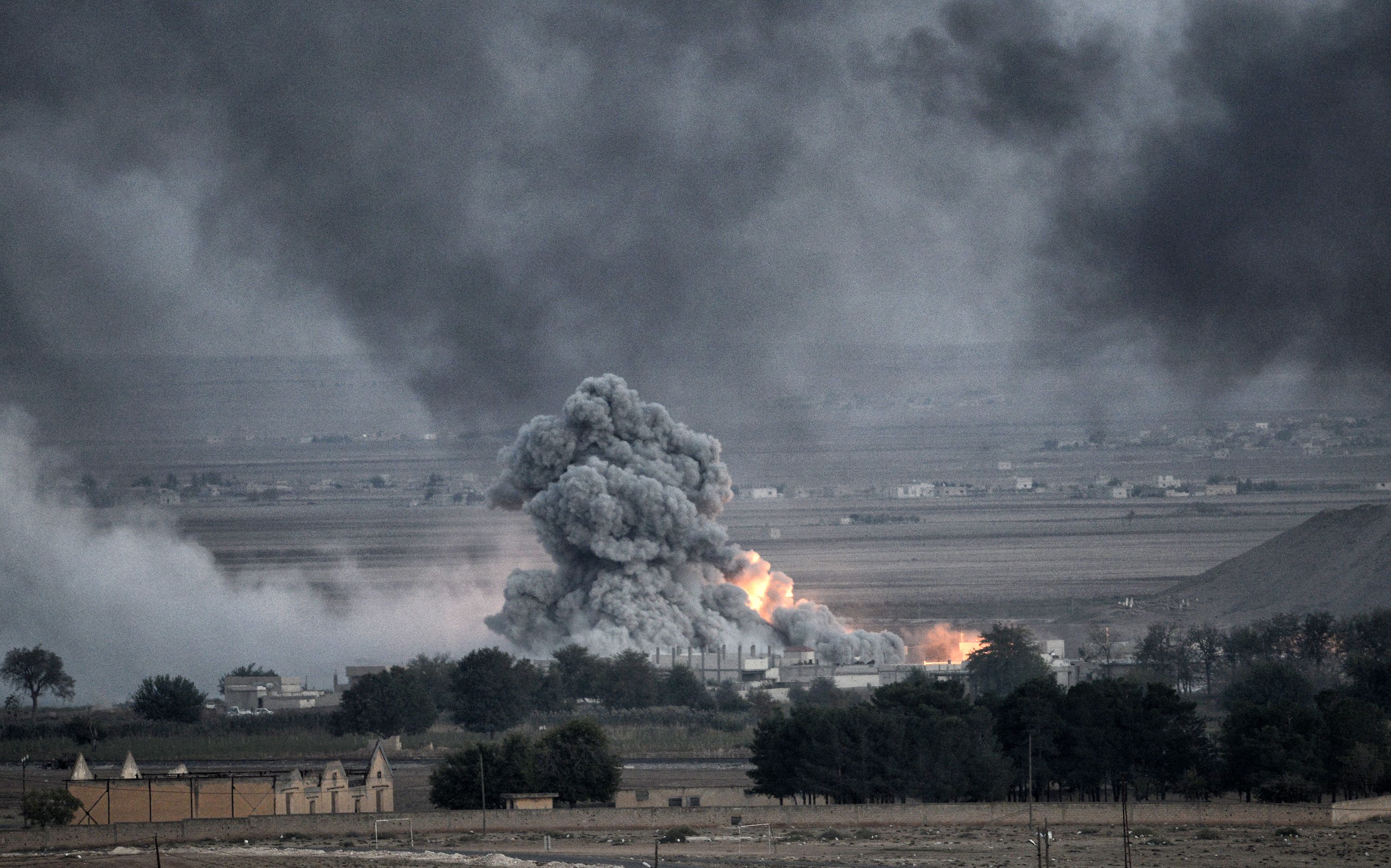 An explosion after an apparent US-led coalition airstrike on Kobane, Syria, as seen from the Turkish side of the border, near Suruc district, 24 October 2014, Sanliurfa, Turkey