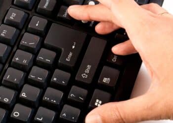 hand pressing ctrl alt delete on black keyboard