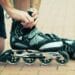 Man preparing for roller blading, putting on rollerblades.