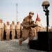 Lance Cpl. Joshua S. Leventhal, a grenadier with Kilo Company, 3rd Battalion, 3rd Marine Regiment, completes Sgt. Joe L. Wrightsman’s battlefield cross by placing boots and identification tags on the monument during a memorial service at Patrol Base Jaker, Afghanistan, July 30. Wrightsman died supporting combat operations July 18.