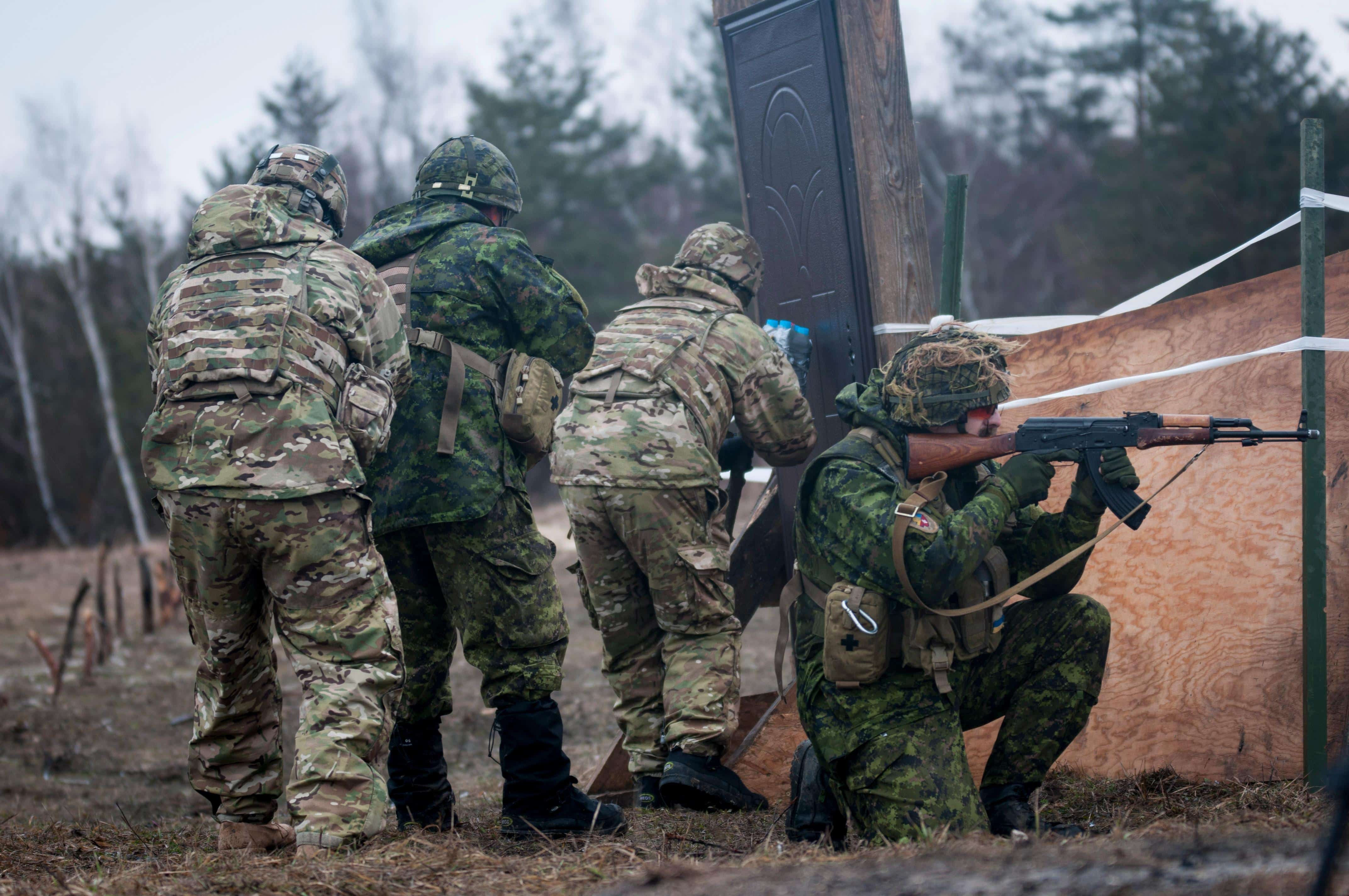 A joint team of Canadian and U.S. Army engineers prepare an explosive charge in order to breach a door while training with Ukrainian combat training center engineers at the International Peacekeeping and Security Center, near Yavoriv, Ukraine, on Feb. 24.
