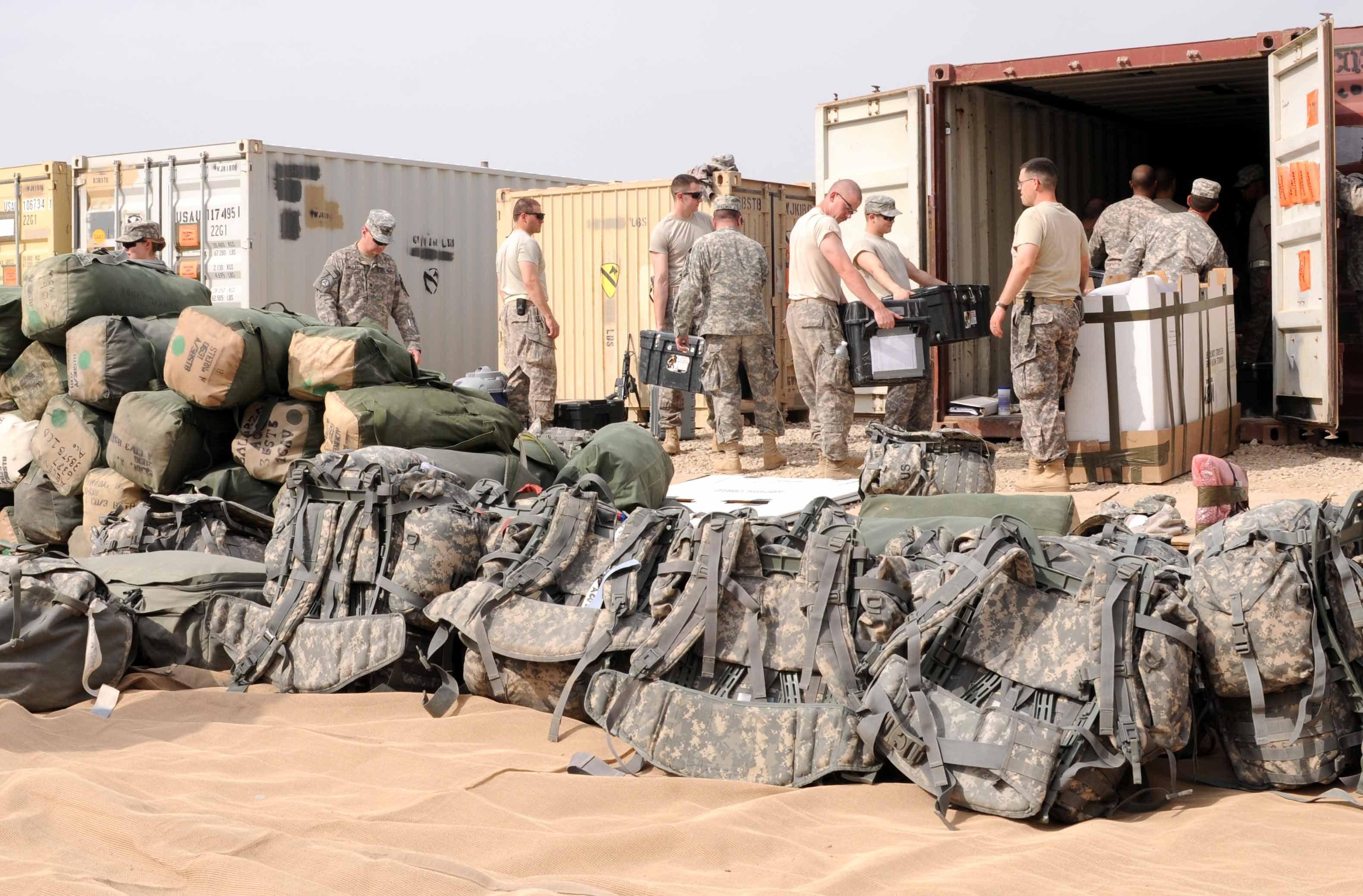Duffel bags and assault packs are stacked in a pile as soldiers from Alpha Company, 3rd Brigade Special Troops Battalion, 1st Cavalry Division from Fort Hood, Texas, load equipment into a cargo container on Contingency Operating Base Adder, Oct. 28.