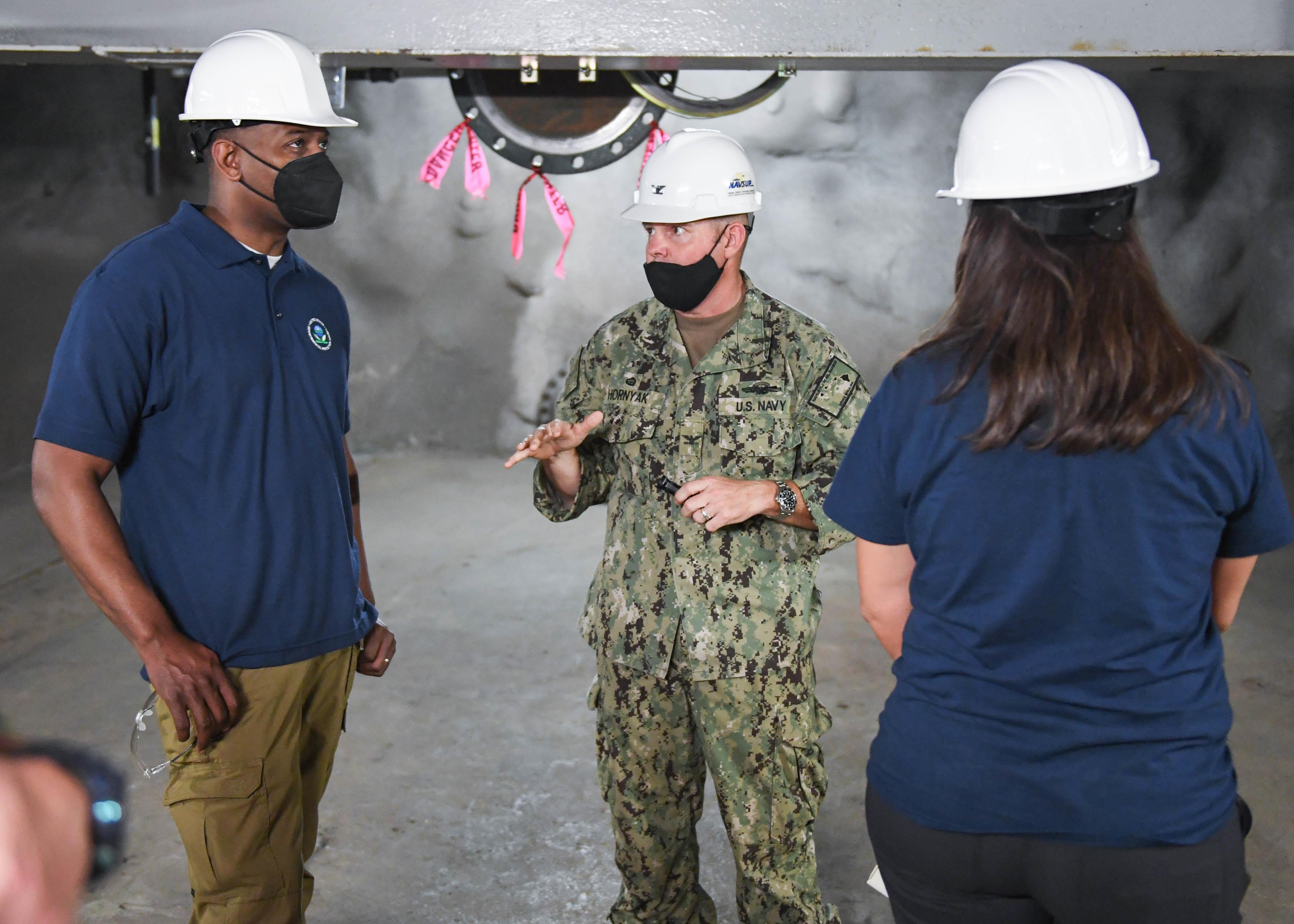 AIEA, Hawaii (Feb. 23, 2022) Capt. Bert Hornyak (center), commanding officer, Naval Supply Systems Command Fleet Logistics Center Pearl Harbor, briefs U.S. Environmental Protection Agency (EPA) Administrator Michael S. Regan (left)