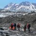 Military and civilian searchers hike across Colony Glacier June 13, 2022, to reach the remnants of a military plane crash. The team is working to recover the remains of 52 passengers and crewmembers, and wreckage of an Air Force C-124 Globemaster aircraft that crashed Nov. 22, 1952