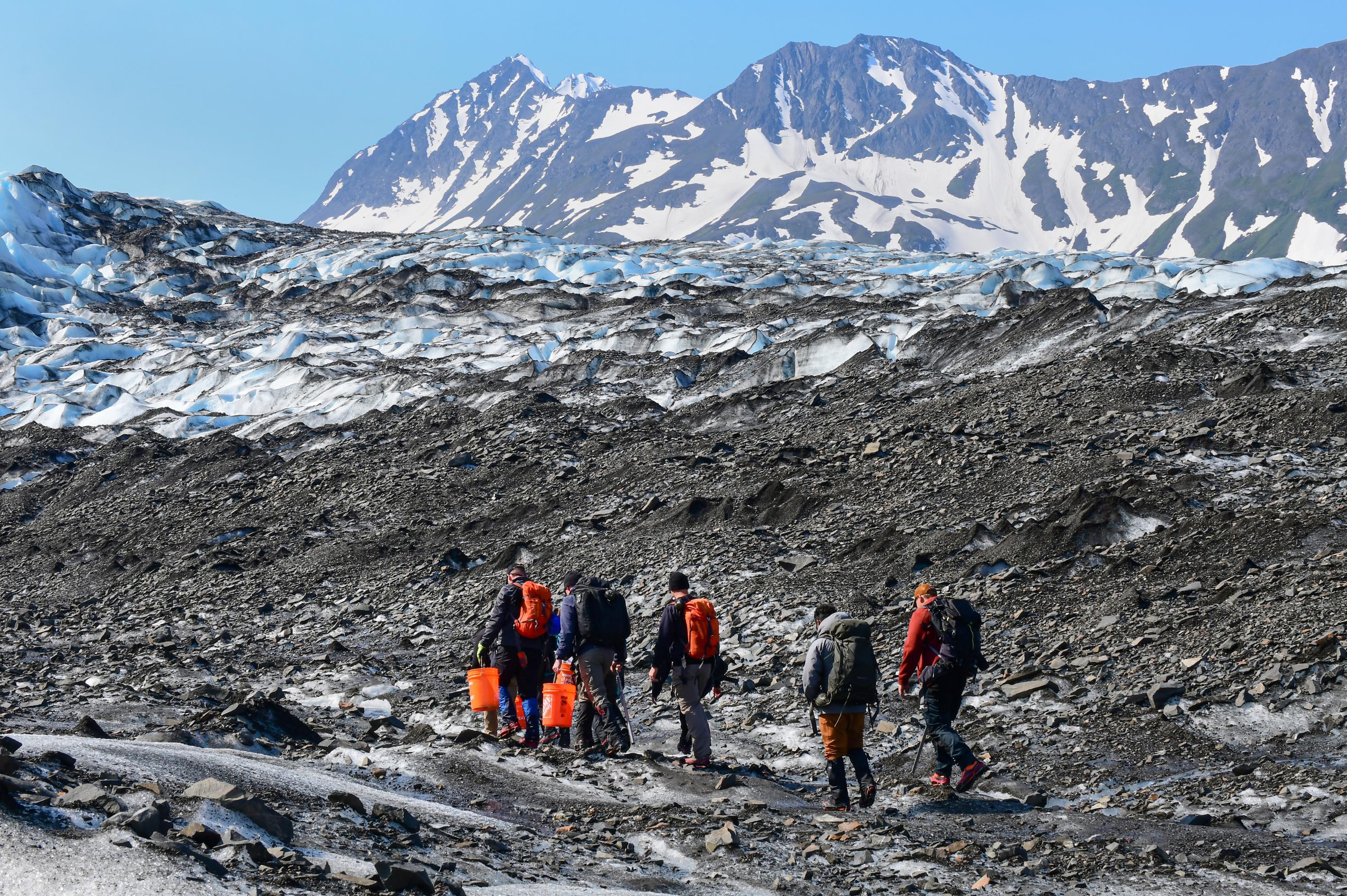 Military and civilian searchers hike across Colony Glacier June 13, 2022, to reach the remnants of a military plane crash. The team is working to recover the remains of 52 passengers and crewmembers, and wreckage of an Air Force C-124 Globemaster aircraft that crashed Nov. 22, 1952