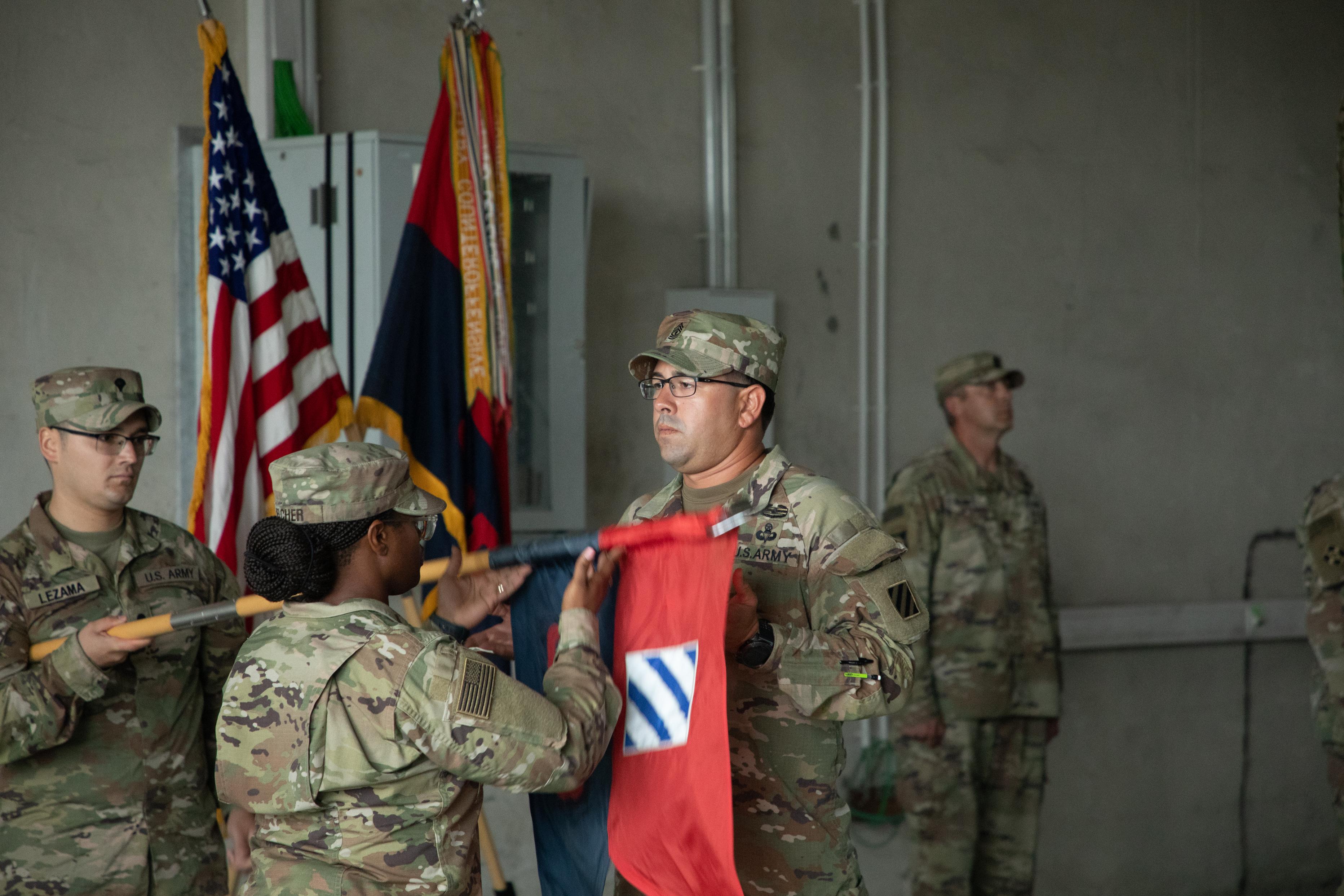U.S. Army Capt. Brittany Belcher, the commander of the Headquarters and Headquarters Company, 3rd Division Sustainment Brigade, 3rd Infantry Division, and 1st Sgt. Angel Geigel, the unit’s senior enlisted leader, uncase their unit guidon during a transfer of authority ceremony in Powdiz, Poland, Aug. 6, 2023. The 3rd DSB has deployed from Fort Stewart, Georgia, to many areas in Europe in Support of Operations European Assure Deter and Reinforce.