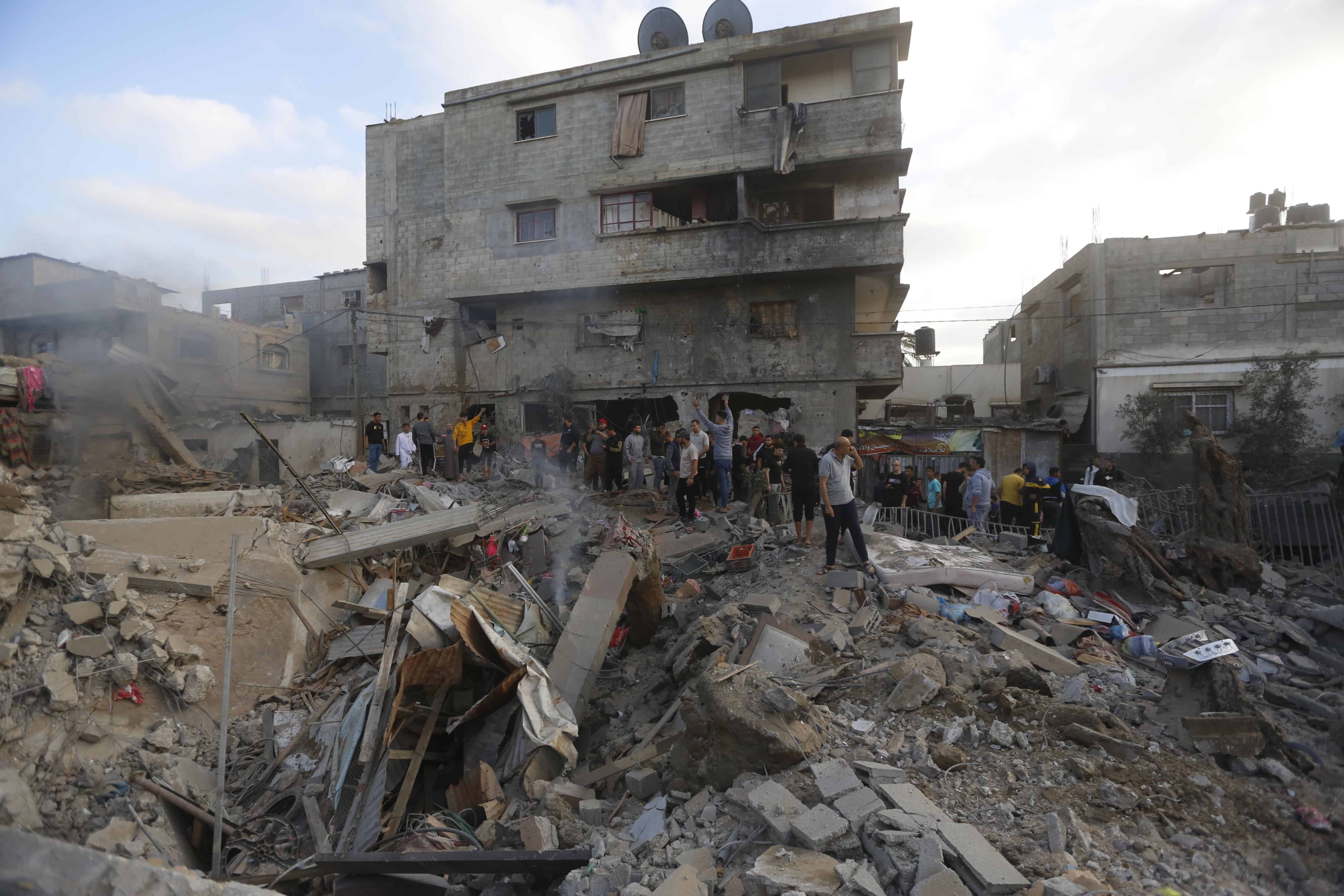 Palestinians inspect the destruction of a house after an Israeli air strike in the city of Gaza Strip, in the southern Gaza Strip, on May 13, 2023.