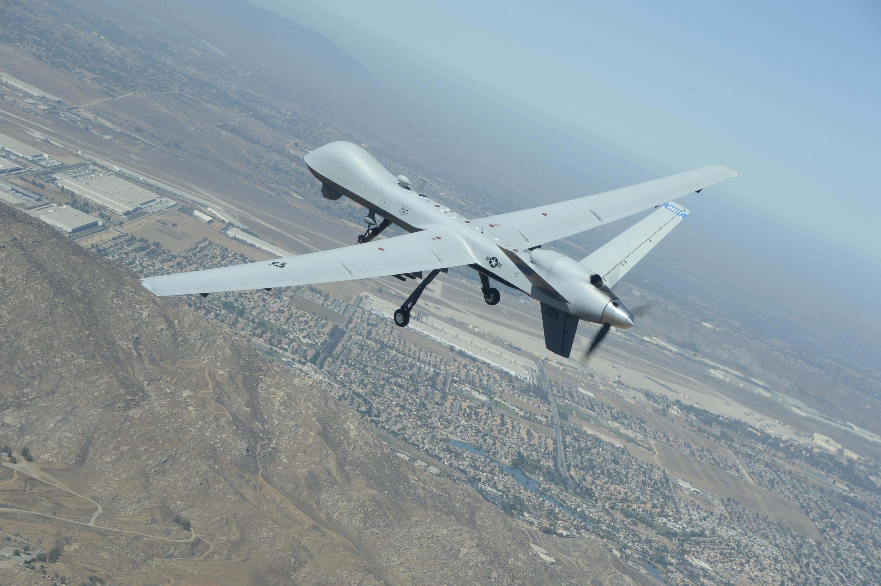 MQ-9 military drone flying through the air and on the airbase