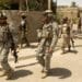 Soldiers with the 2nd Battalion, 506th Infantry Regiment, walk through the streets of Al Dora during Operation Together Freedom, Aug. 10. U.S. troops along with Iraqi National Police searched and cleared homes in Dora looking fo weapons, explosives, caches and ammunition.