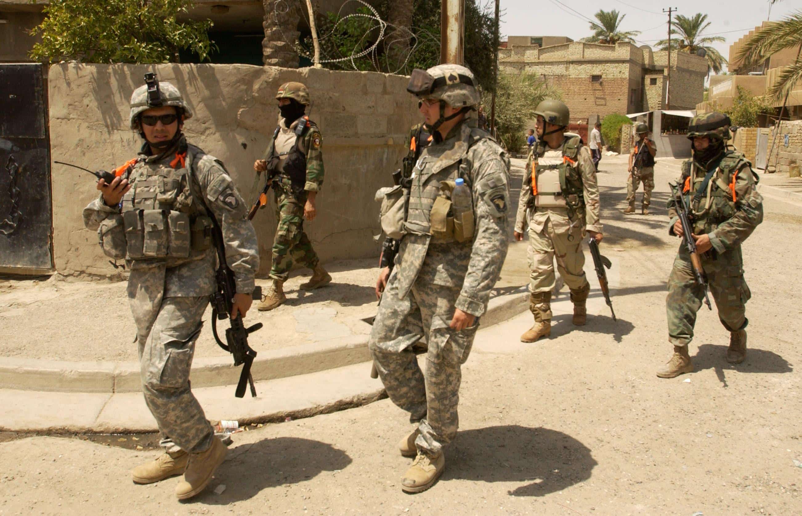Soldiers with the 2nd Battalion, 506th Infantry Regiment, walk through the streets of Al Dora during Operation Together Freedom, Aug. 10. U.S. troops along with Iraqi National Police searched and cleared homes in Dora looking fo weapons, explosives, caches and ammunition.