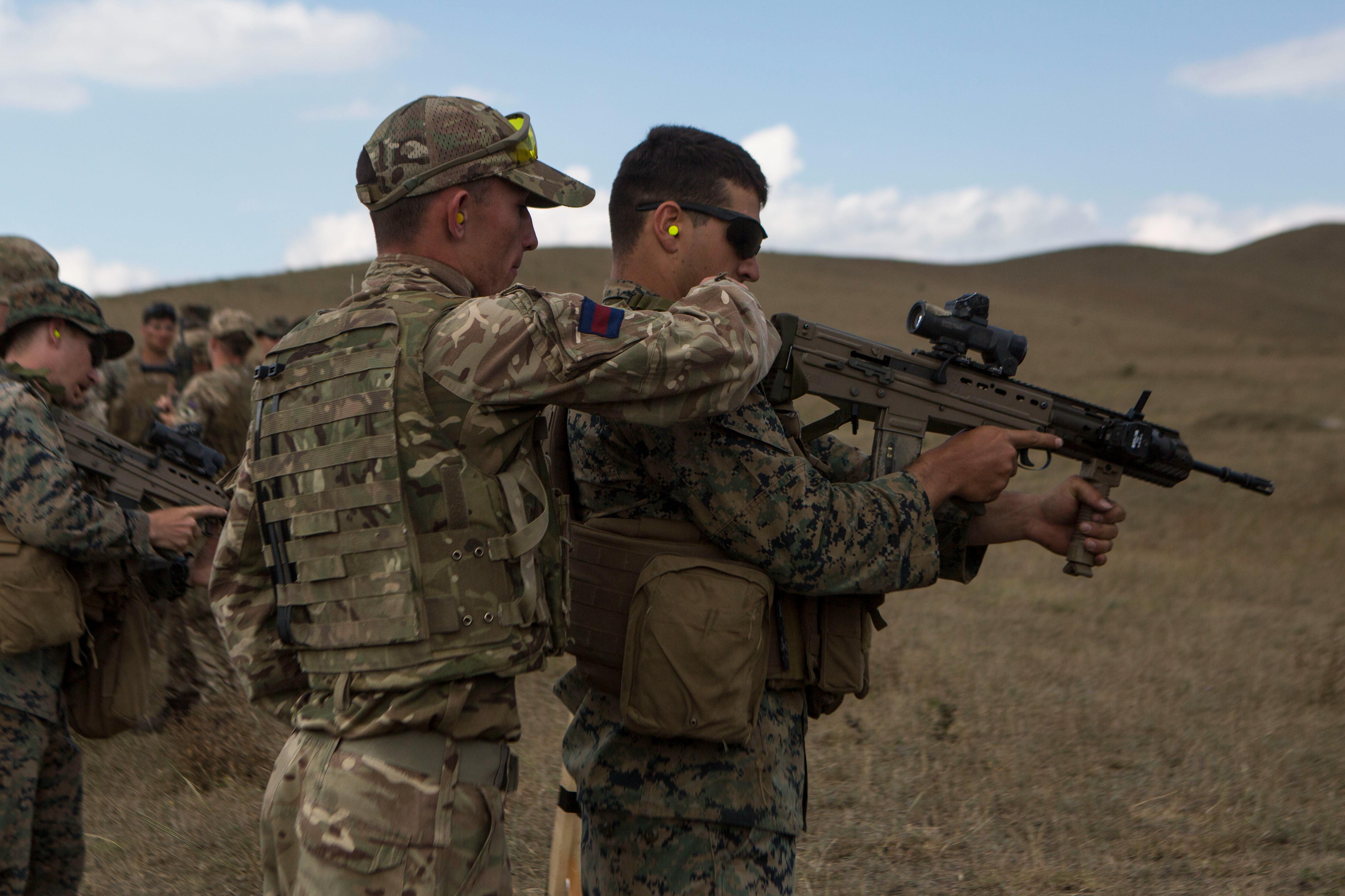 A U.K. Army soldier with Irish Guards shows A U.S. Marine with Marine Rotational Force-Europe 19.2, Marine Forces Europe and Africa, how to fire a L85A3 rifle during exercise Agile Spirit 2019 in Orpholo, Georgia, August 2, 2019. AgS19 is a joint, multinational exercise that enhances U.S., Georgian, allied and partner forces lethality, interoperability and readiness in a realistic training environment. (U.S. Marine Corps photo by Lance Cpl. Larisa Chavez)