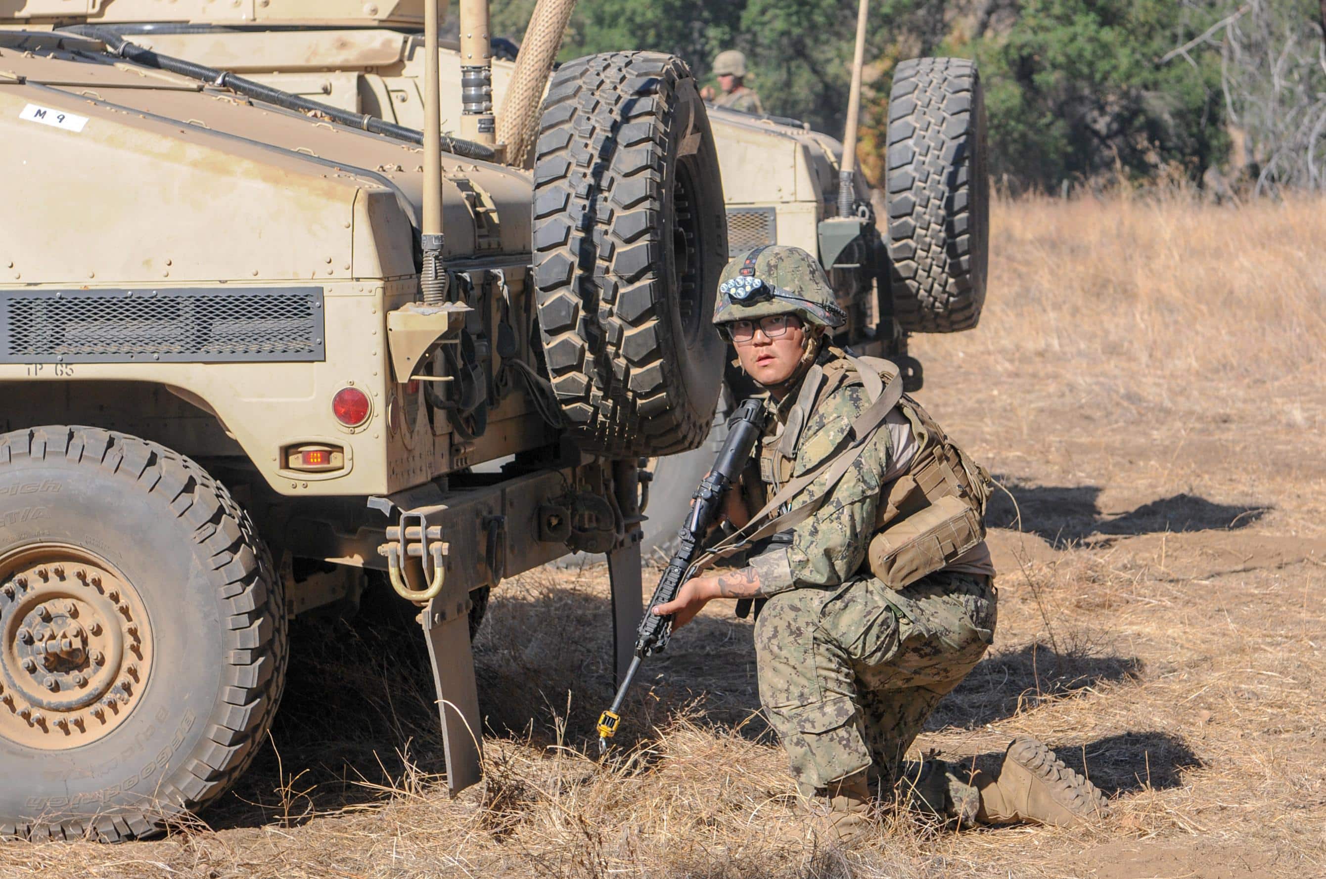 191113-N-TP832-1100 FORT HUNTER LIGGETT, Calif. (Nov. 13, 2019) Construction Electrician 3rd Class Wenheng Zhao, assigned to Naval Mobile Construction Battalion (NMCB) 3, uses an M4 rifle to defend an entry control point from a simulated enemy attack during NMCB-3’s field training exercise (FTX) at Fort Hunter Liggett, Calif.