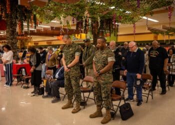 U.S. Marine Corps Sgt. Maj. Collin D. Barry, sergeant major, Marine Corps Base Quantico, left, and U.S. Marine Corps Col. Michael L. Brooks, base commander, MCB Quantico, right, bow their heads in prayer with Vietnam War veterans during the National Vietnam War Veterans Day commemoration ceremony at MCB Quantico, Virginia, March 29, 2023. In 2017, President Donald Trump declared National Vietnam War Veterans Day because on this day in 1973, U.S. combat troops departed the Republic of Vietnam. (U.S. Marine Corps photo by Lance Cpl. Joaquin Dela Torre)