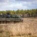 German soldiers assigned to the 93 Armored Demonstration Battalion, 9th Panzerlehr Brigade, 1st Panzer Division, maneuver a Leopard 2A6 tank onto the range during a combined arms live fire exercise in Bemowo Piskie, Poland, April 3, 2023. The 4th Infantry Division’s mission in Europe is to engage in multinational training and exercises across the continent, working alongside NATO allies and regional security partners to provide combat-credible forces to V Corps, America’s forward deployed corps in Europe. (U.S. Army National Guard photo by Sgt. John Schoebel)