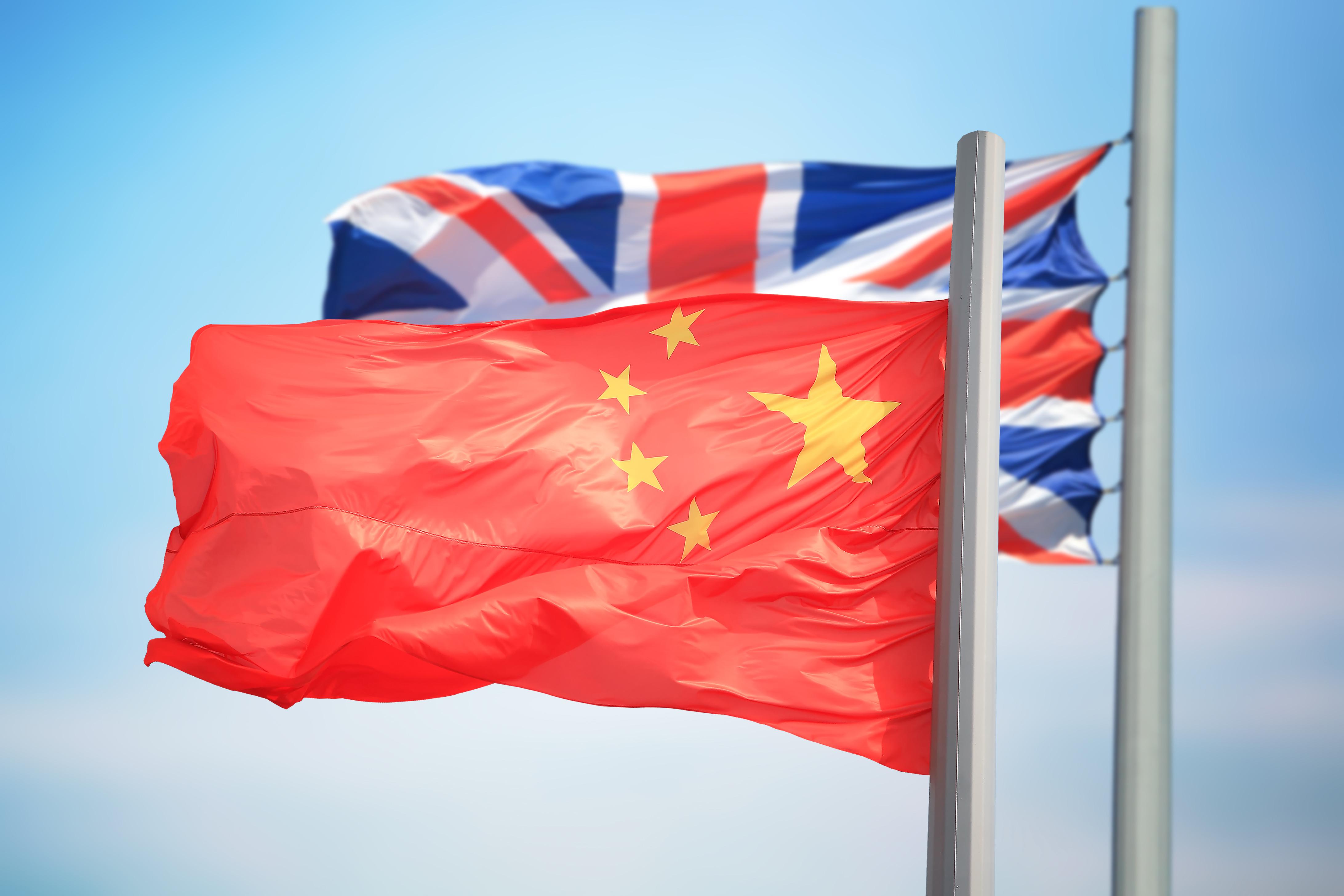 Flags of China and Great Britain against the background of the blue sky