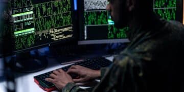 Hacker in military unifrorm on dark web, cyberwar concept.