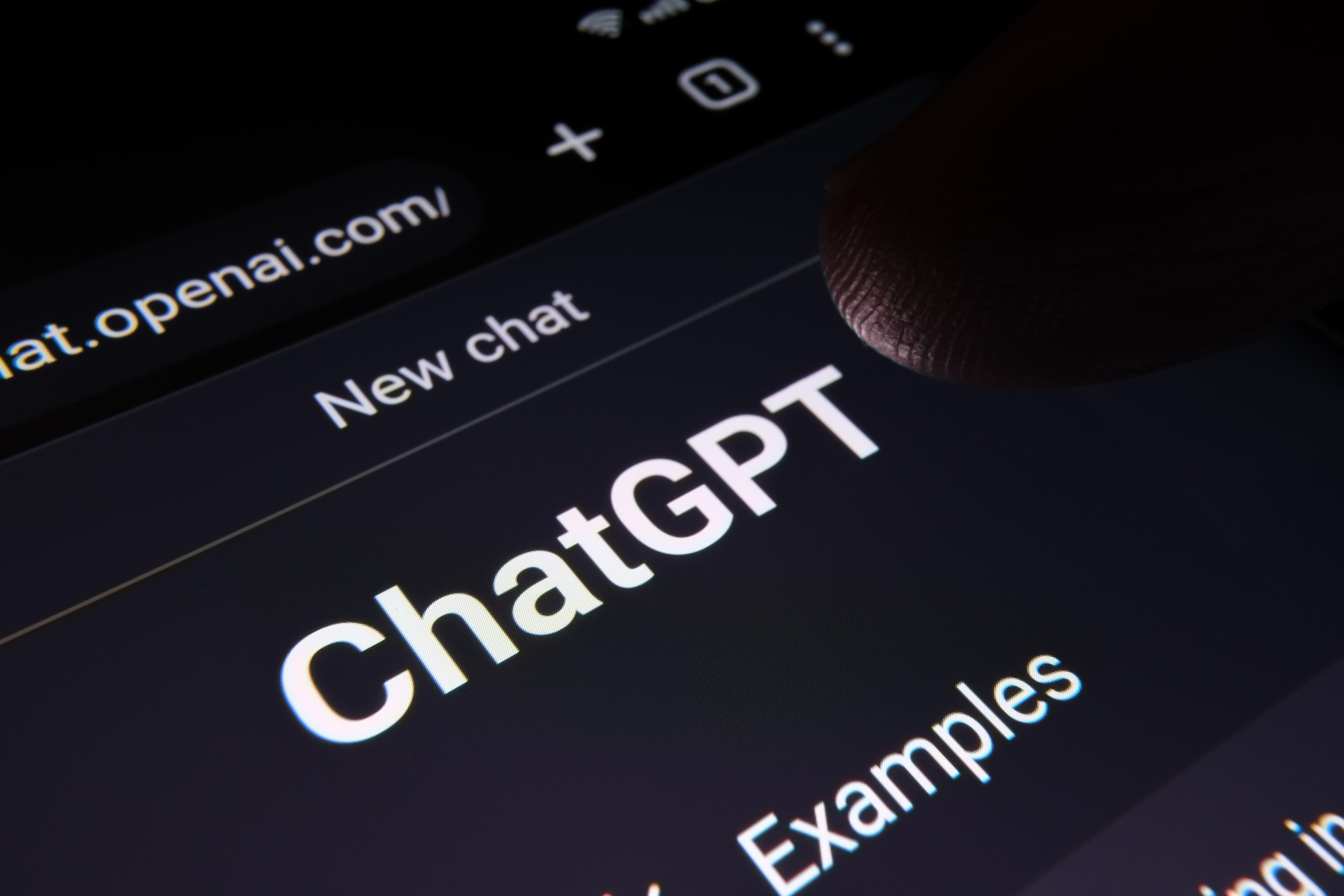 Finger touching ChatGPT chat bot screen seen on smartphone display with large Chat GPT logo. AI chatbot by OpenAI. Macro photo. Stafford, United Kingdom, February 19, 2023