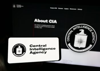 Stuttgart, Germany - 10-29-2023: Person holding mobile phone with logo of American Central Intelligence Agency (CIA) in front of web page. Focus on phone display. Unmodified photo.