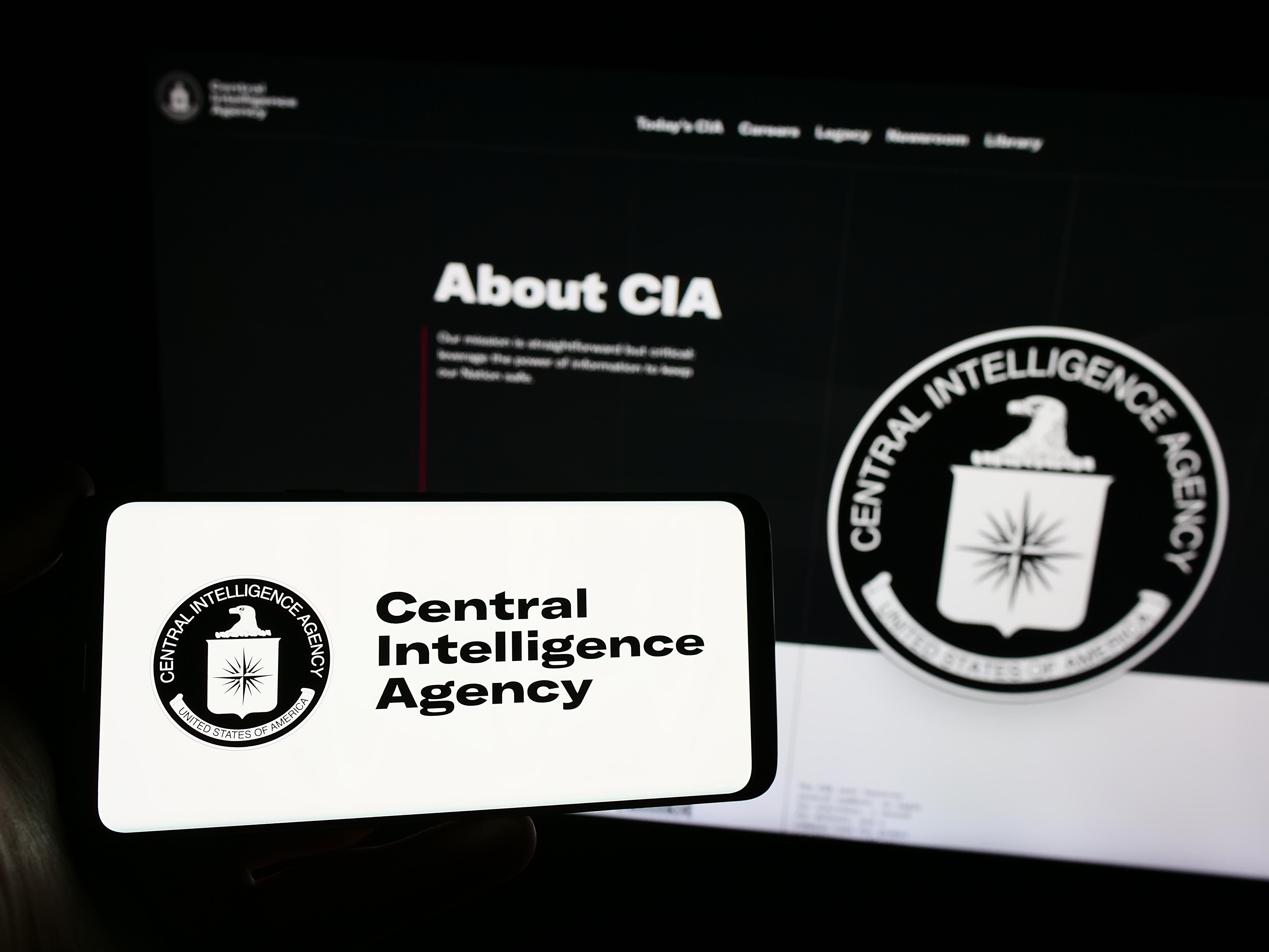 Stuttgart, Germany - 10-29-2023: Person holding mobile phone with logo of American Central Intelligence Agency (CIA) in front of web page. Focus on phone display. Unmodified photo.