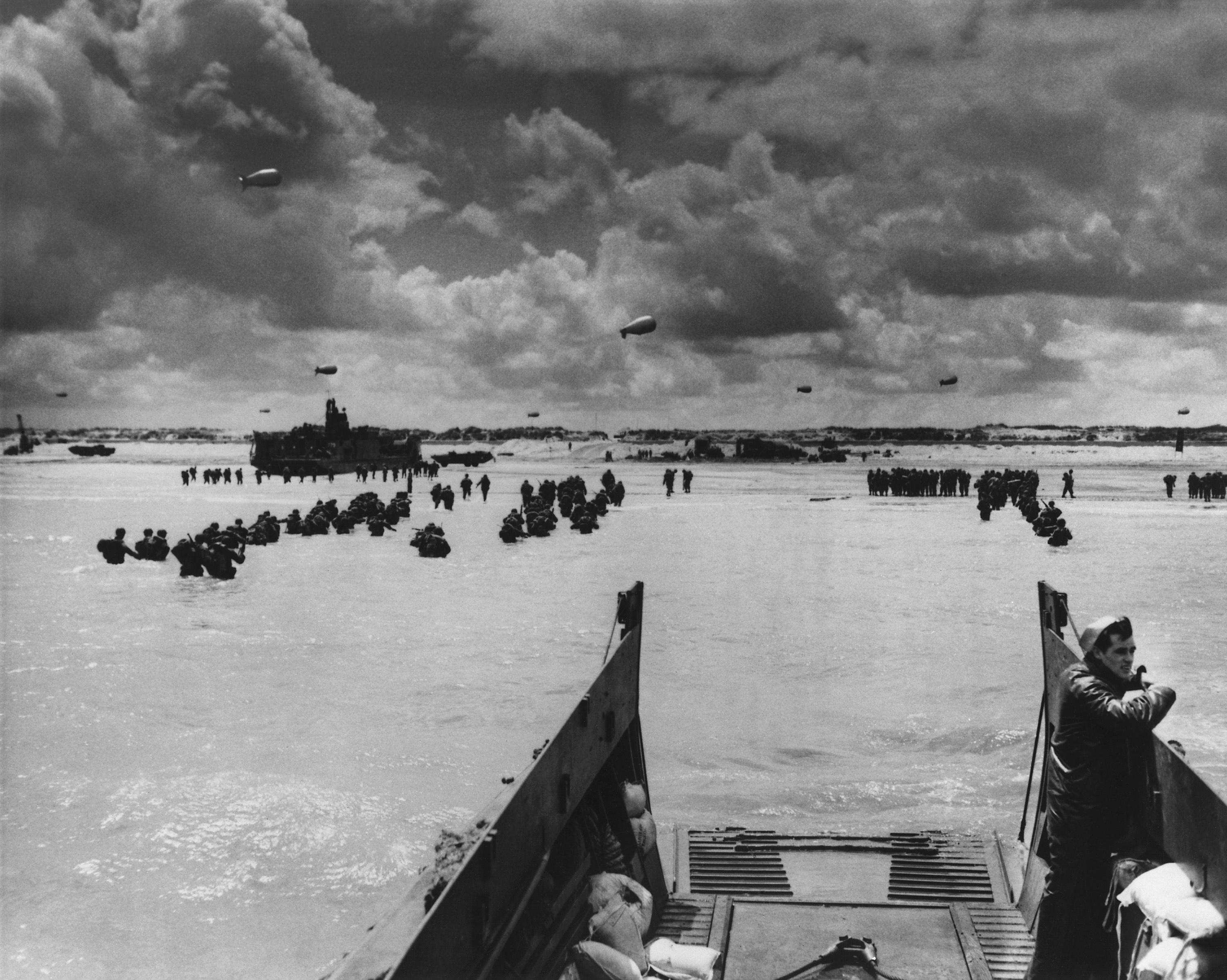 U.S. Troops land at Normandy on D-Day. With the beach taken and barrage balloons deterring German aircraft, soldiers and supplies flooded into France in June 1944, during World War 2.