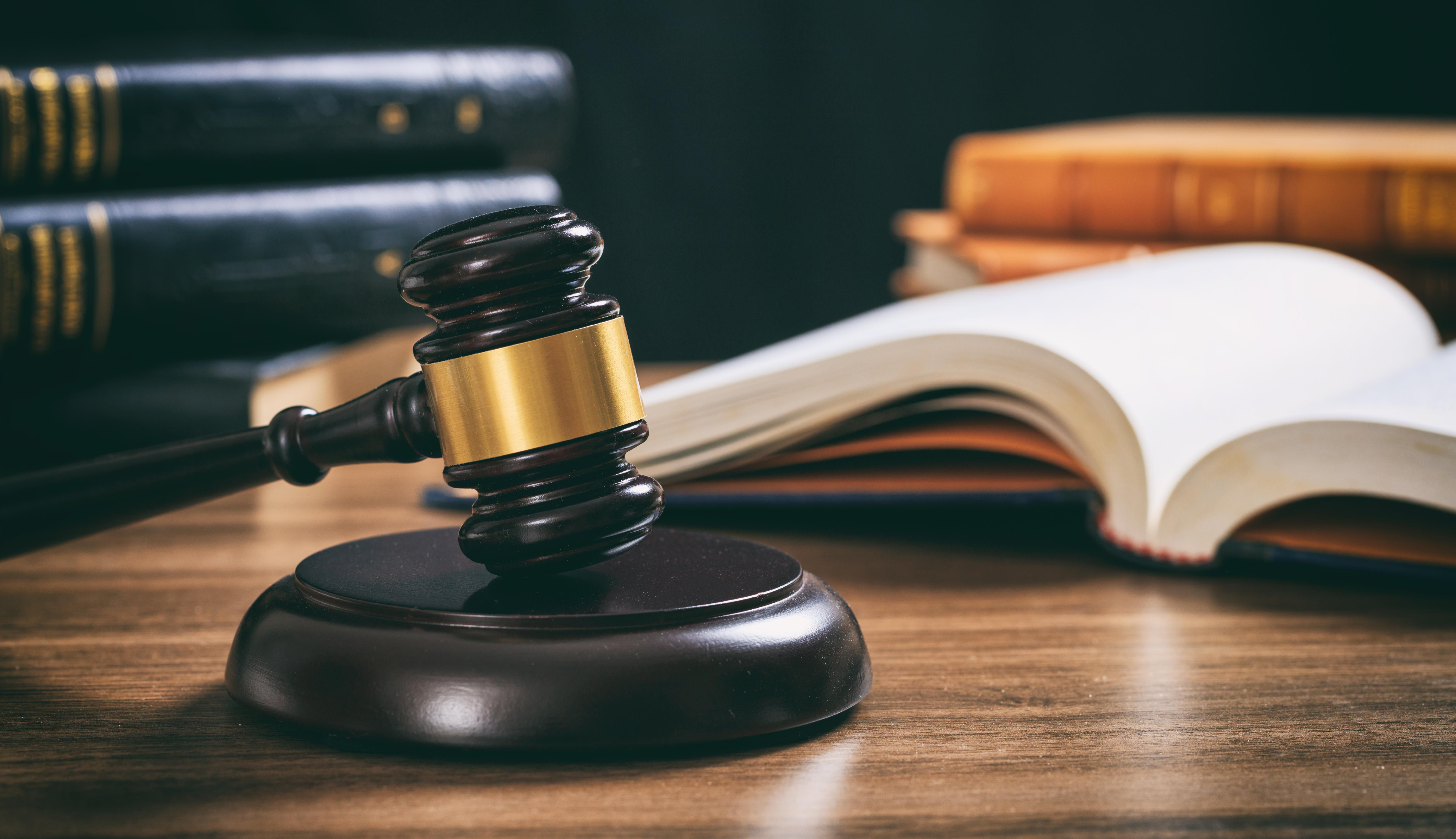 Law studies. Judge gavel on a wooden desk, blur legal books background