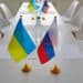 Ukraine and Russia flags on negotiation table before delegates start peace talks considering Ukrainian terms and demands to cease fire, halt aggression, stop war, end conflict and exchange prisoners
